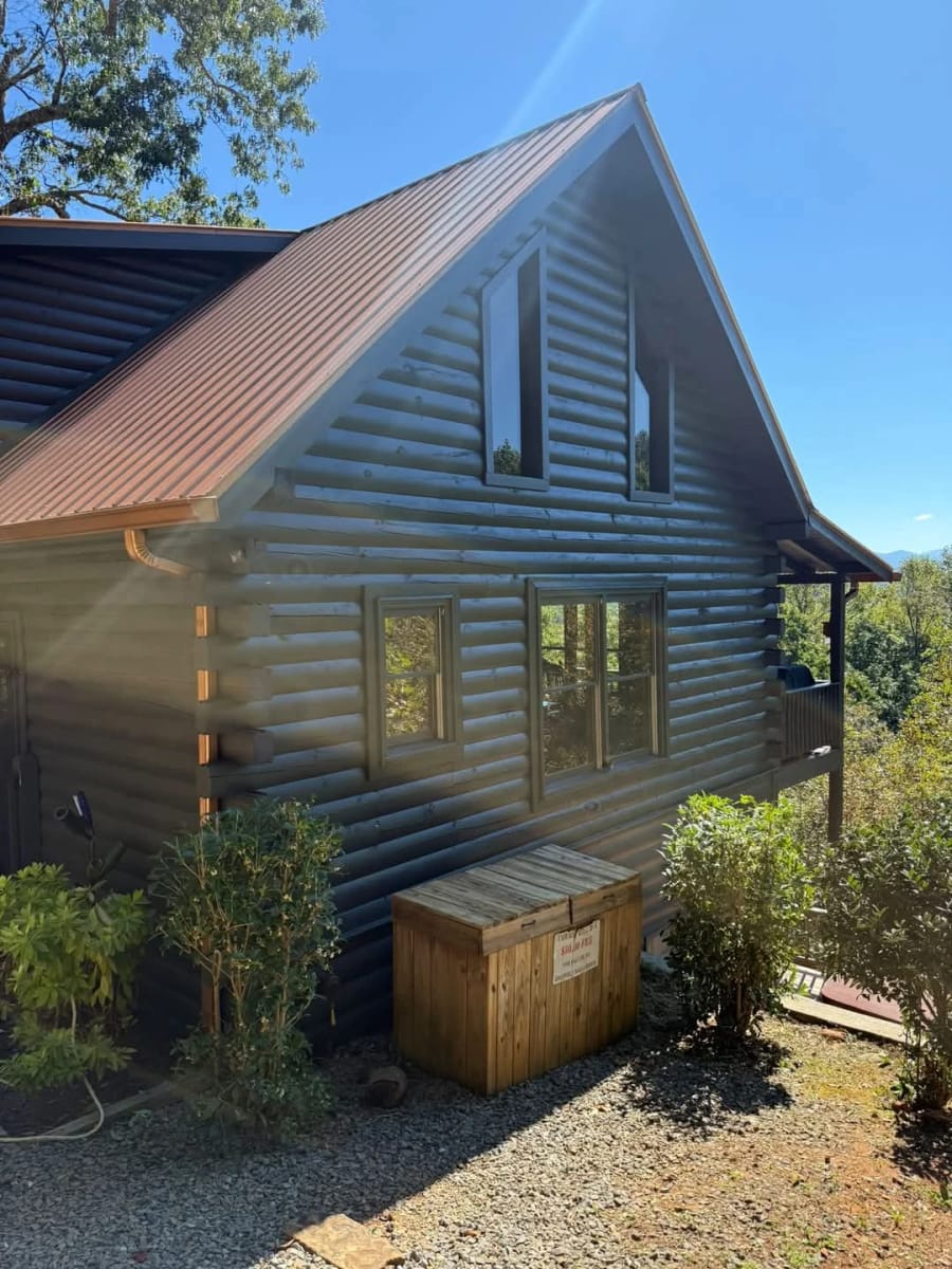 Log cabin gable end with a copper roof and mountain view